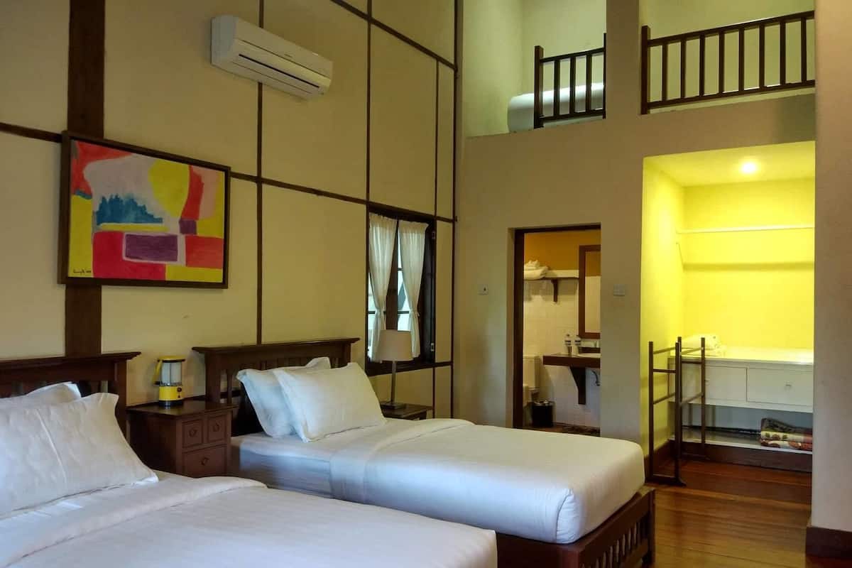Habitación de hotel con dos camas, un cuadro, aire acondicionado y vistas a un balcón.