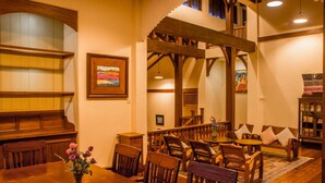 A dining area with wooden furniture, a vase of flowers, and a painting on the wall. - Bulaeinn Villas (Bago)