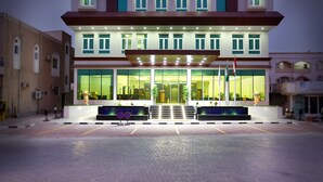 Ein modernes Hotel mit großzügigem Eingangsbereich, Glastüren und einer gut beleuchteten Fassade.