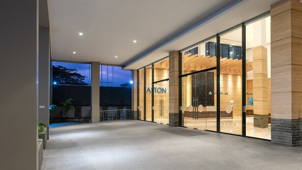 A modern hotel entrance with a glass facade, a reception desk, and a well-lit outdoor area. - Aston Inn Tasikmalaya (Tasikmalaya)