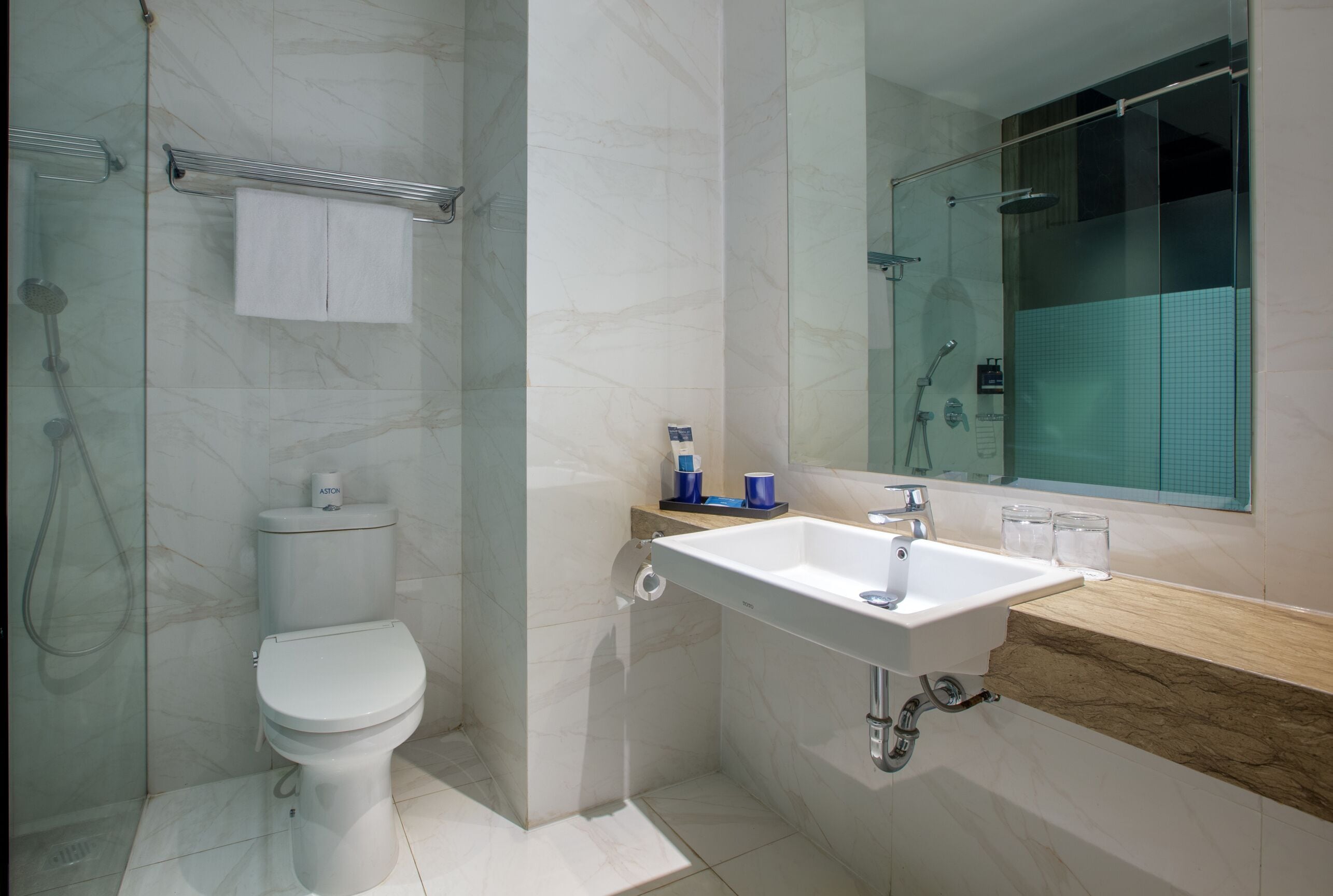 A modern bathroom with a toilet, sink, and shower.