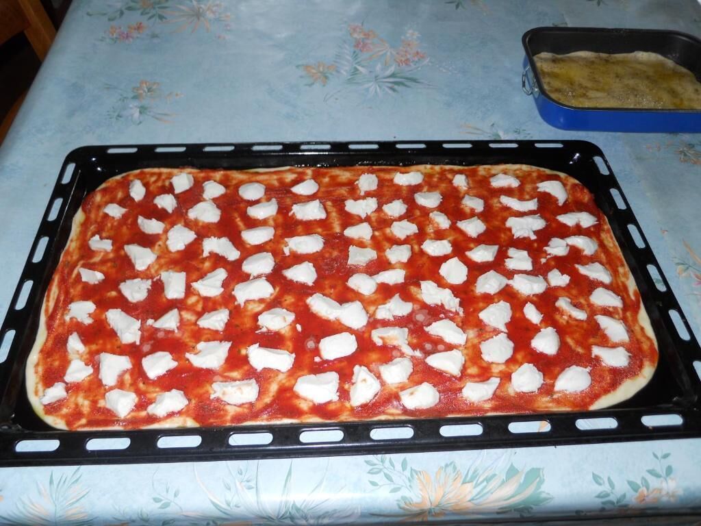 Une pizza sur une plaque de cuisson, posée sur une table.