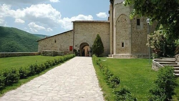 A stone building with a paved pathway leading to an arched entrance. - Agriturismo Monti Sibillini Camperato (Preci)