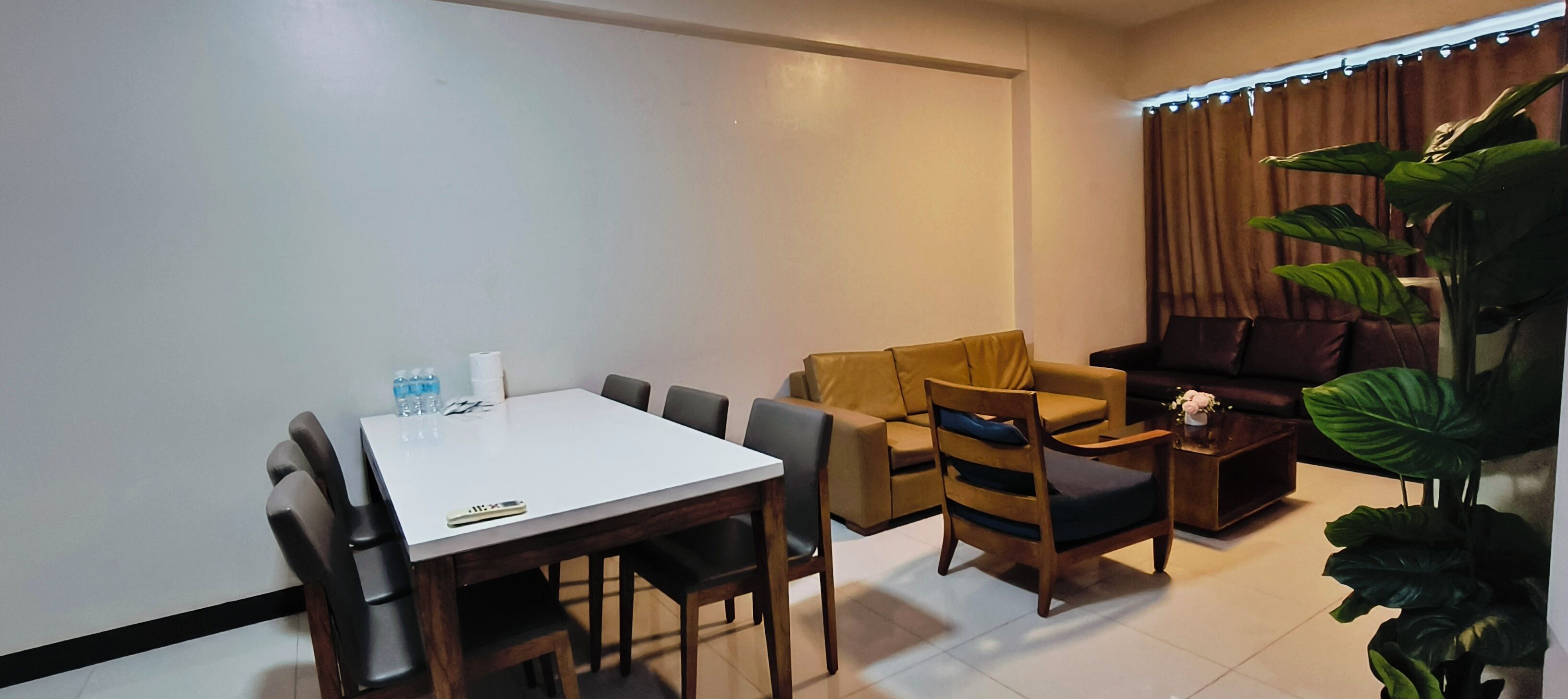 A modern living room with a dining table, sofa, and chairs.