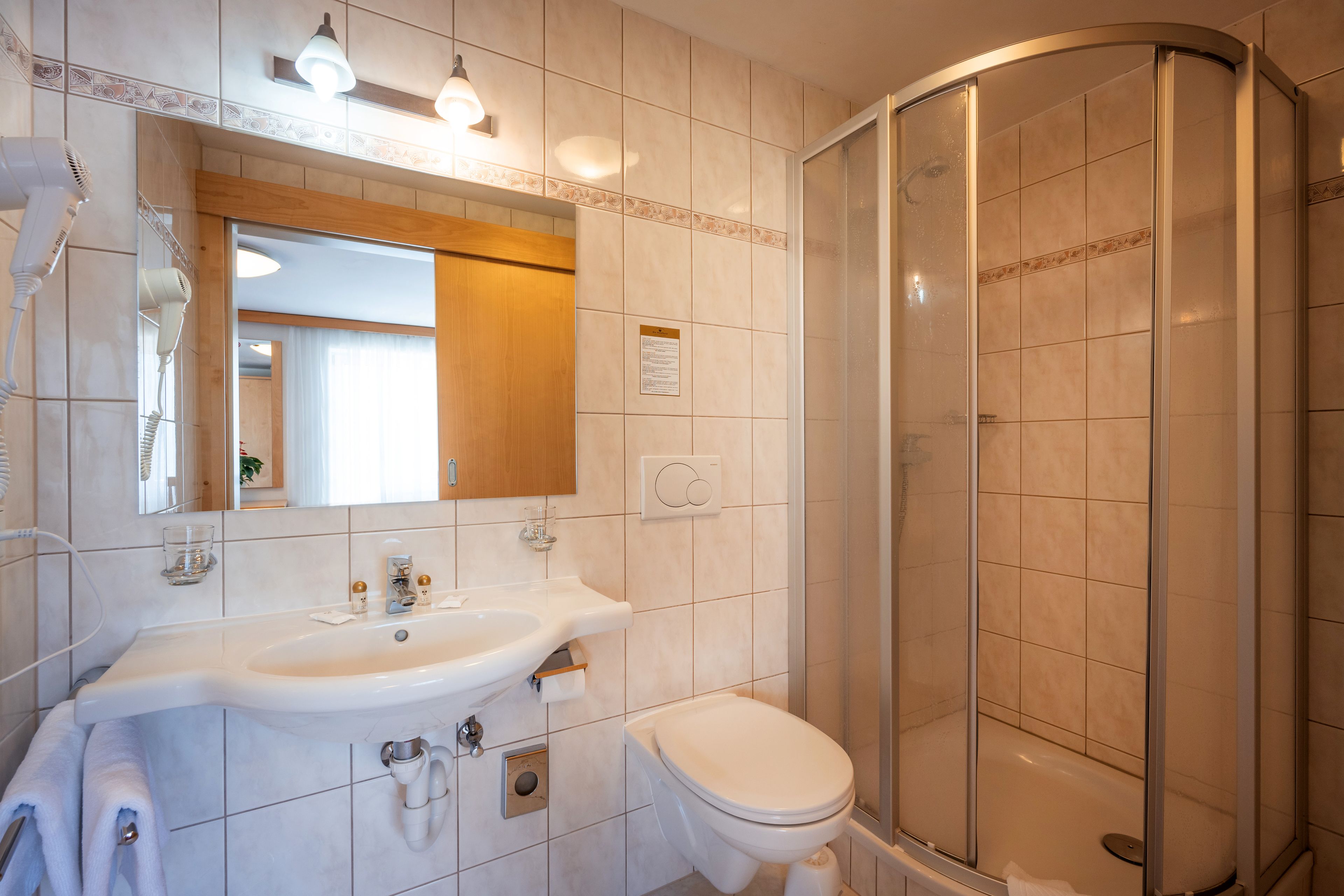 Un baño con lavamanos, espejo e inodoro.