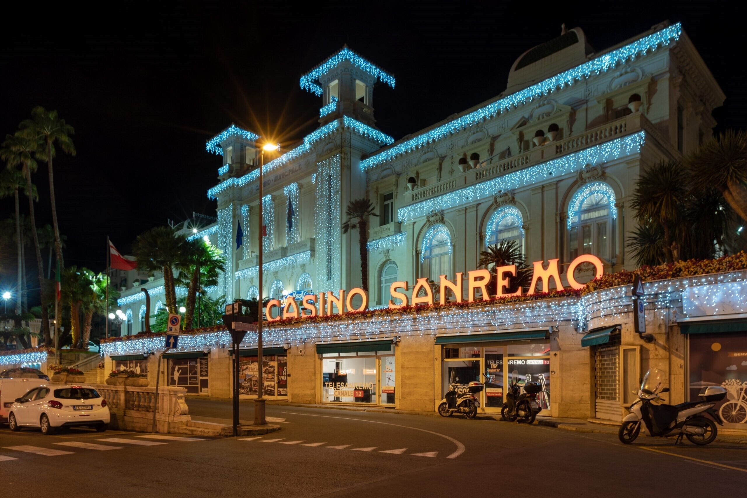 A building with the sign "CASINO SANREMO" and a classic architectural style with arched windows and decorative elements.