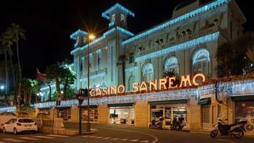 A building with the sign "CASINO SANREMO" and a classic architectural style with arched windows and decorative elements.
