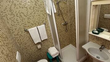 Une salle de bain avec des toilettes, un lavabo et une douche.