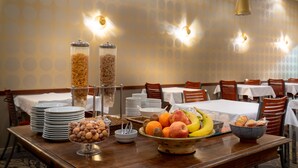 Un bufé de desayuno con diversas frutas y cereales.