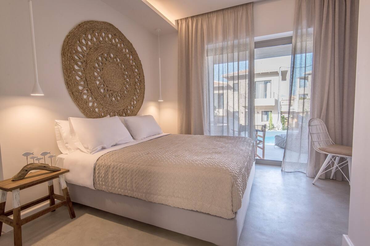 Un dormitorio moderno con una cama grande, un tapiz decorativo y vistas al balcón.