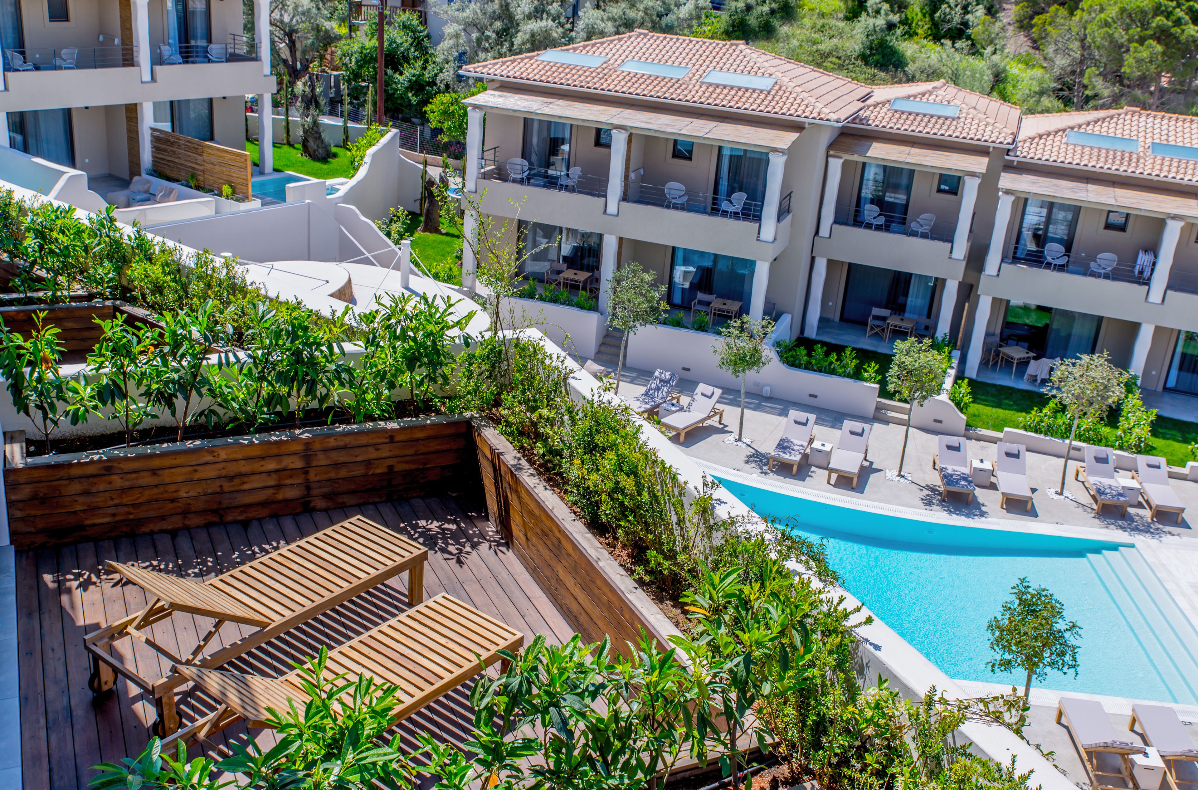 A resort with a swimming pool, wooden deck, and multiple balconies.