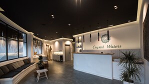 Una recepción moderna con zona de estar, mostrador de recepción y un amplio ventanal con vistas.