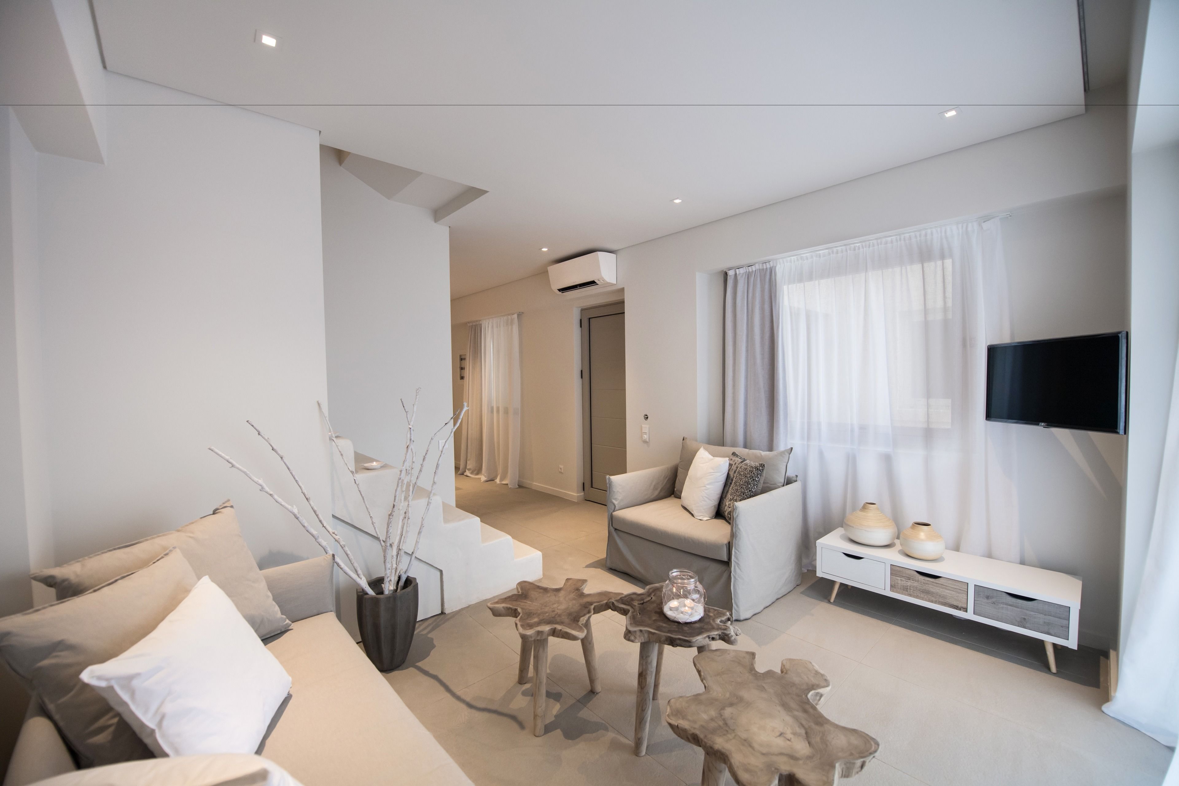 Una sala de estar moderna con un sofá, una mesa de centro y un televisor.