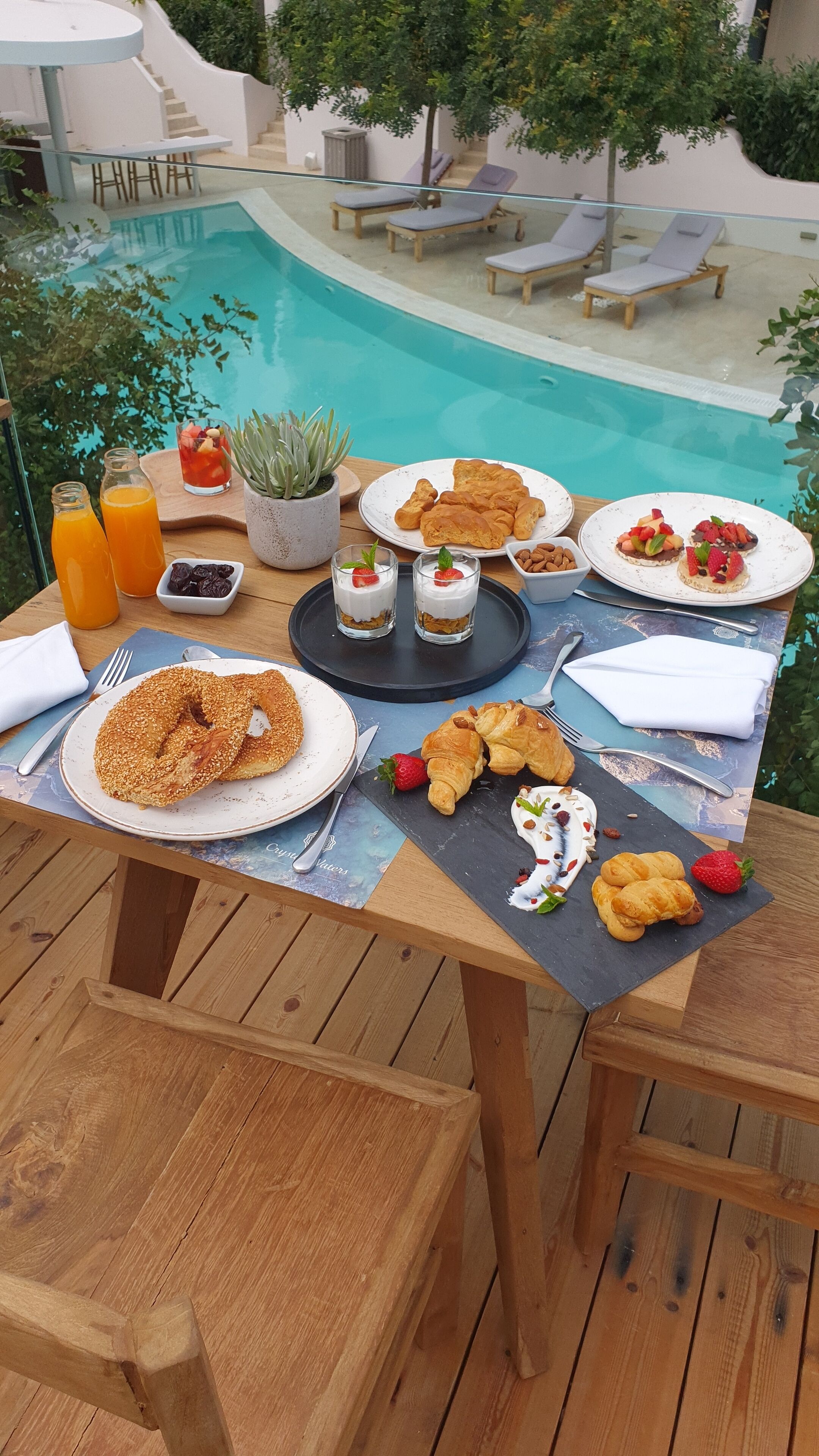 A dining table with breakfast items and a pool view.