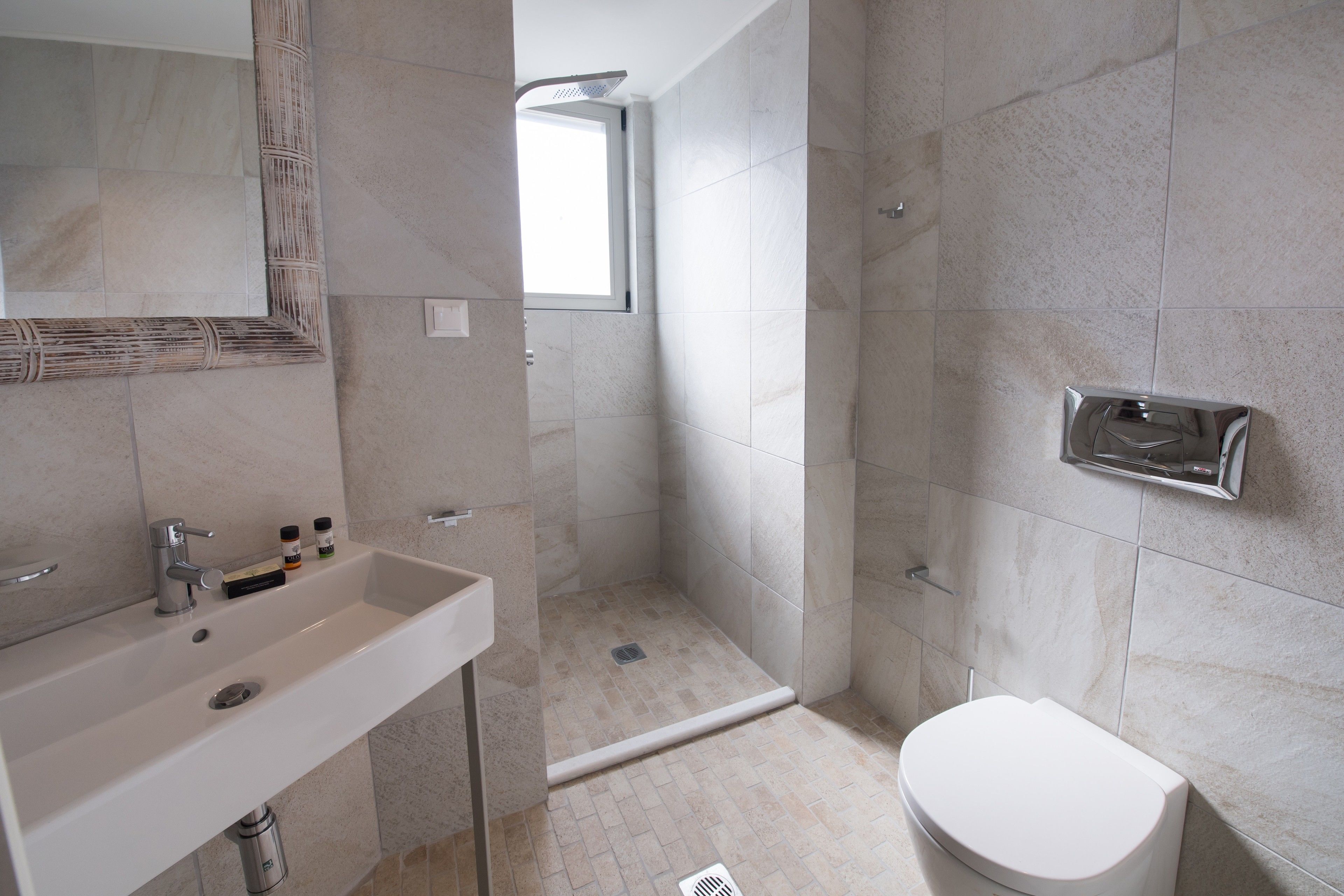 Une salle de bain moderne équipée d’un lavabo, de toilettes et d’une zone douche.