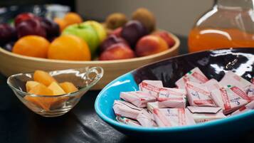 Un tavolo con ciotole contenenti frutta e prodotti alimentari confezionati.