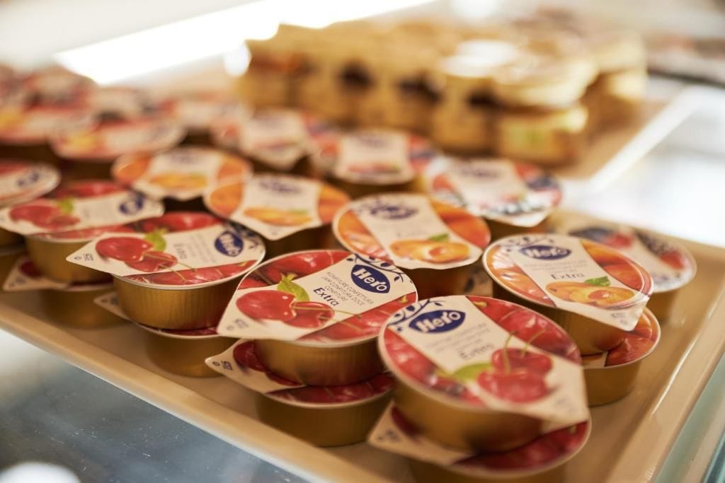A display of packaged food items, likely yogurt, with labels indicating flavors such as strawberry and peach.