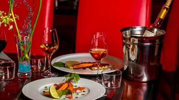 Une table à manger avec différents plats, des verres et une bouteille de champagne.