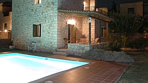 A stone building with a swimming pool, a balcony, and a small patio area. - Christina Villas (Heraklion)