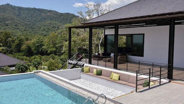Zona de piscina exterior moderna con vistas despejadas a un paisaje montañoso.