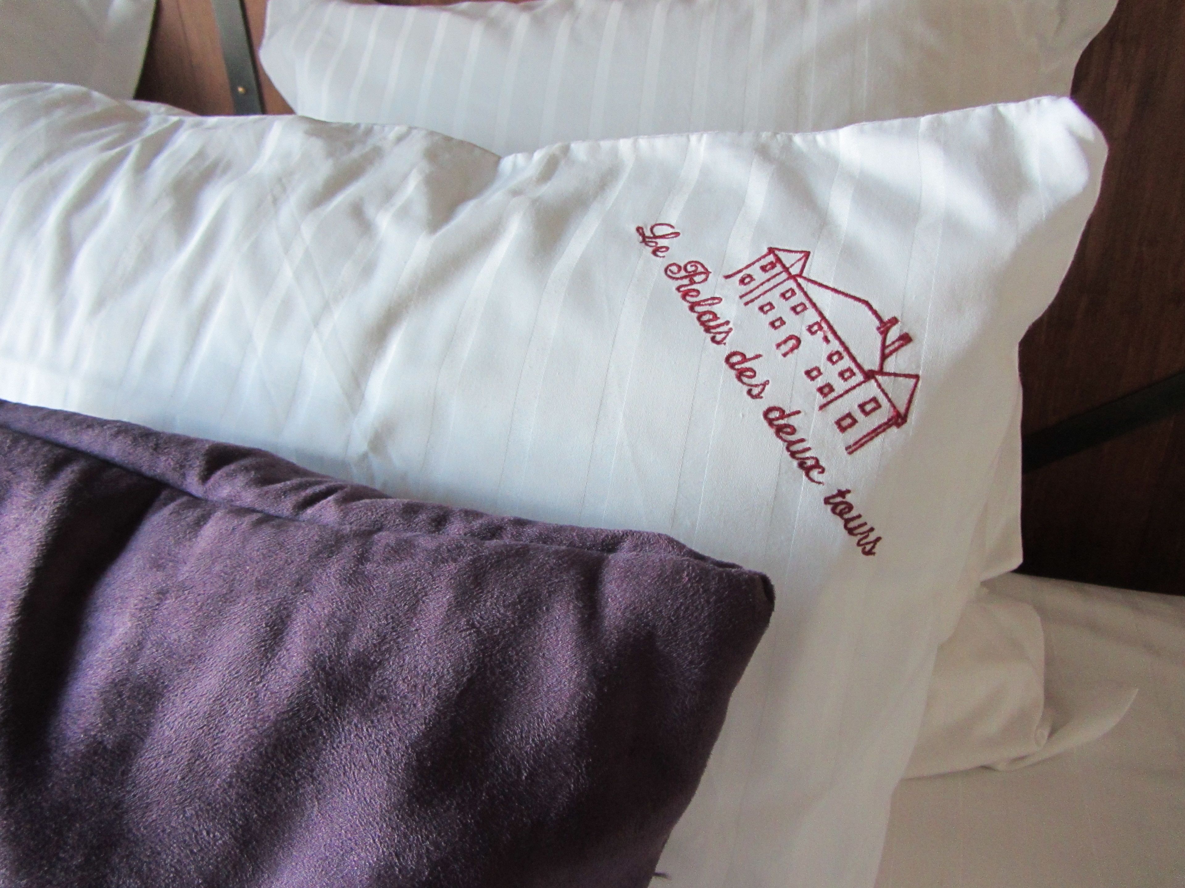 Un coussin orné d’une image de maison et d’un texte dans une langue étrangère.
