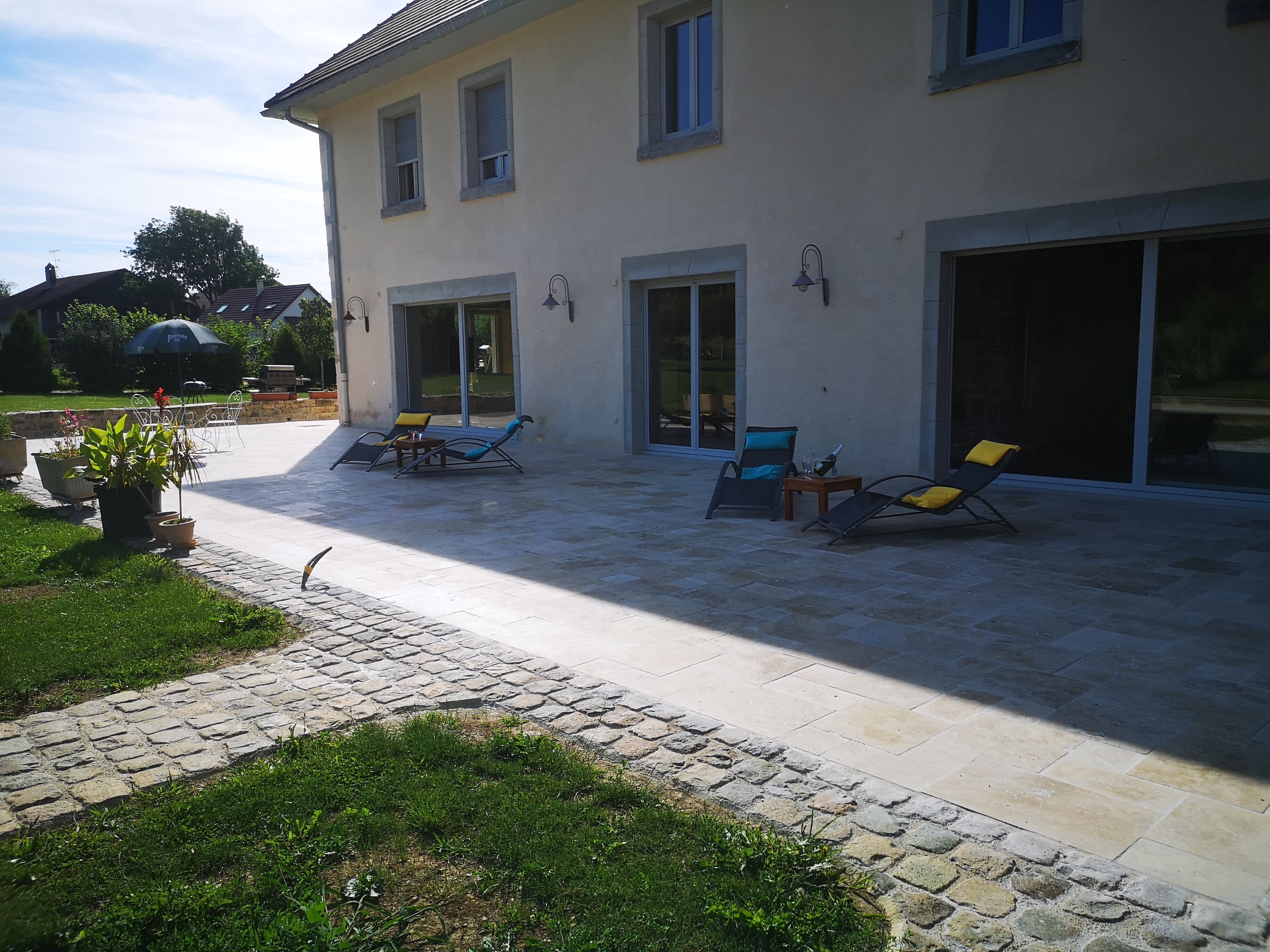 A house with a patio area featuring outdoor furniture and a garden.