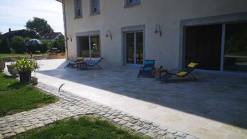 A house with a patio area featuring outdoor furniture and a garden.