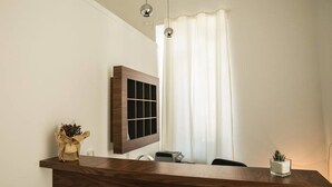 A modern kitchen with a wooden countertop, a built-in window, and a hanging light fixture. - Al Tartarughino B&B (Cercola)