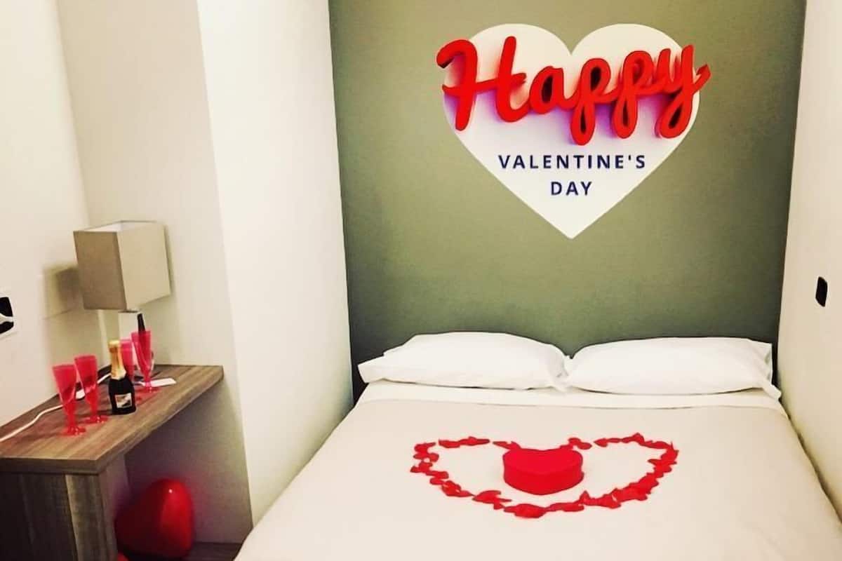 A bedroom with a bed, a nightstand, and a wall decoration.