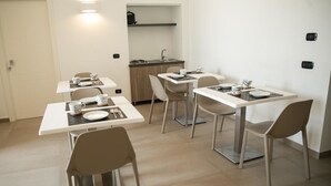 A compact dining area with a small kitchenette, including a sink and a stove. - Al Tartarughino B&B (Cercola)