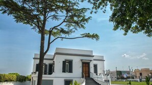 A modern two-story house with a front entrance, a staircase, and a well-maintained lawn. - Al Tartarughino B&B (Cercola)