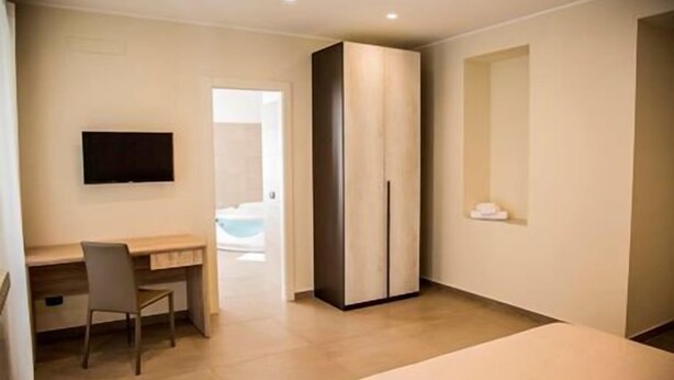 A bedroom with a bed, a desk, a chair, and a wardrobe. - Al Tartarughino B&B (Cercola)