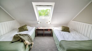 A room with two single beds, a small desk, and a skylight. - Apelviken Lägenhetshotell (Varberg)
