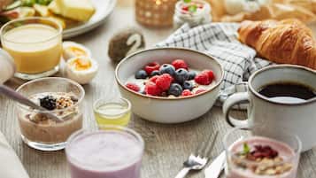Une table dressée pour le petit-déjeuner, avec divers aliments et boissons.