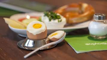 A table with a plate of food, including a boiled egg and a pastry.