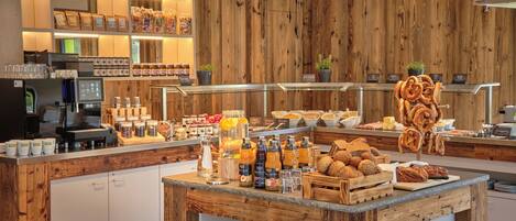 A breakfast buffet with various food items, beverages, and condiments.