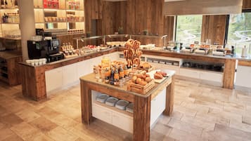 A breakfast buffet with various food items and a coffee station.