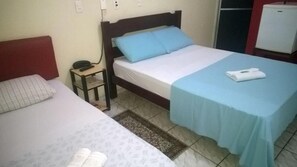 A hotel room with two beds, a bedside table with a phone, and a small refrigerator. - Hotel Pousada Aeroporto (Goiania)