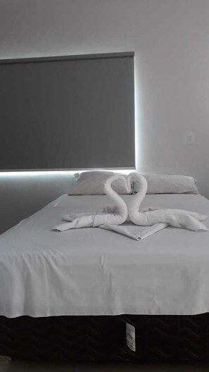 A hotel room with a bed, a headboard, and a pillow. - Hotel Pousada Aeroporto (Goiania)