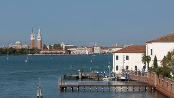 A waterfront view with a pier, boats, and buildings in the background.