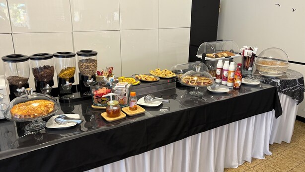 A buffet setup with various food items and condiments. - Hotel Wega (Bellaria-Igea Marina)