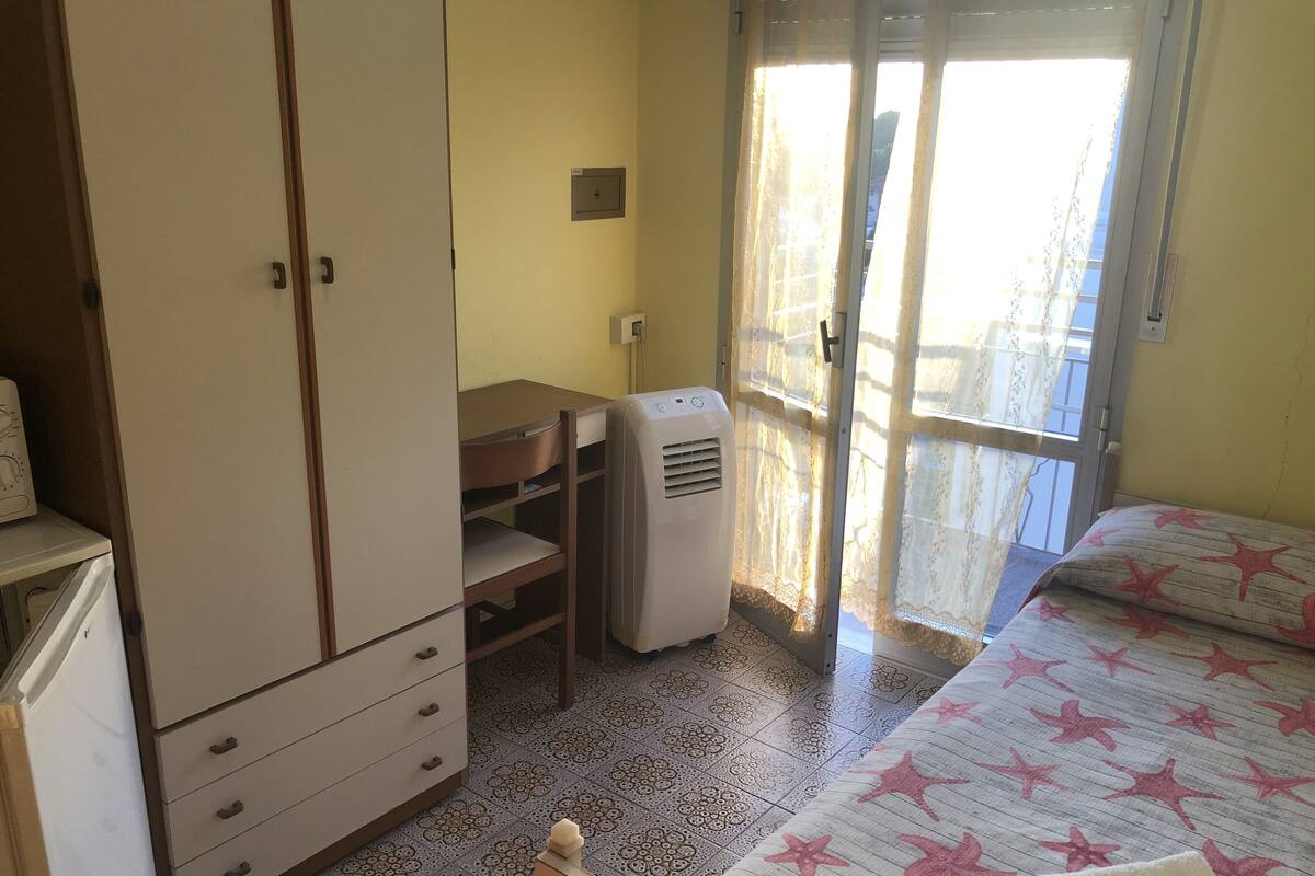 Une chambre à coucher comprenant un lit, une armoire, un bureau et un radiateur.