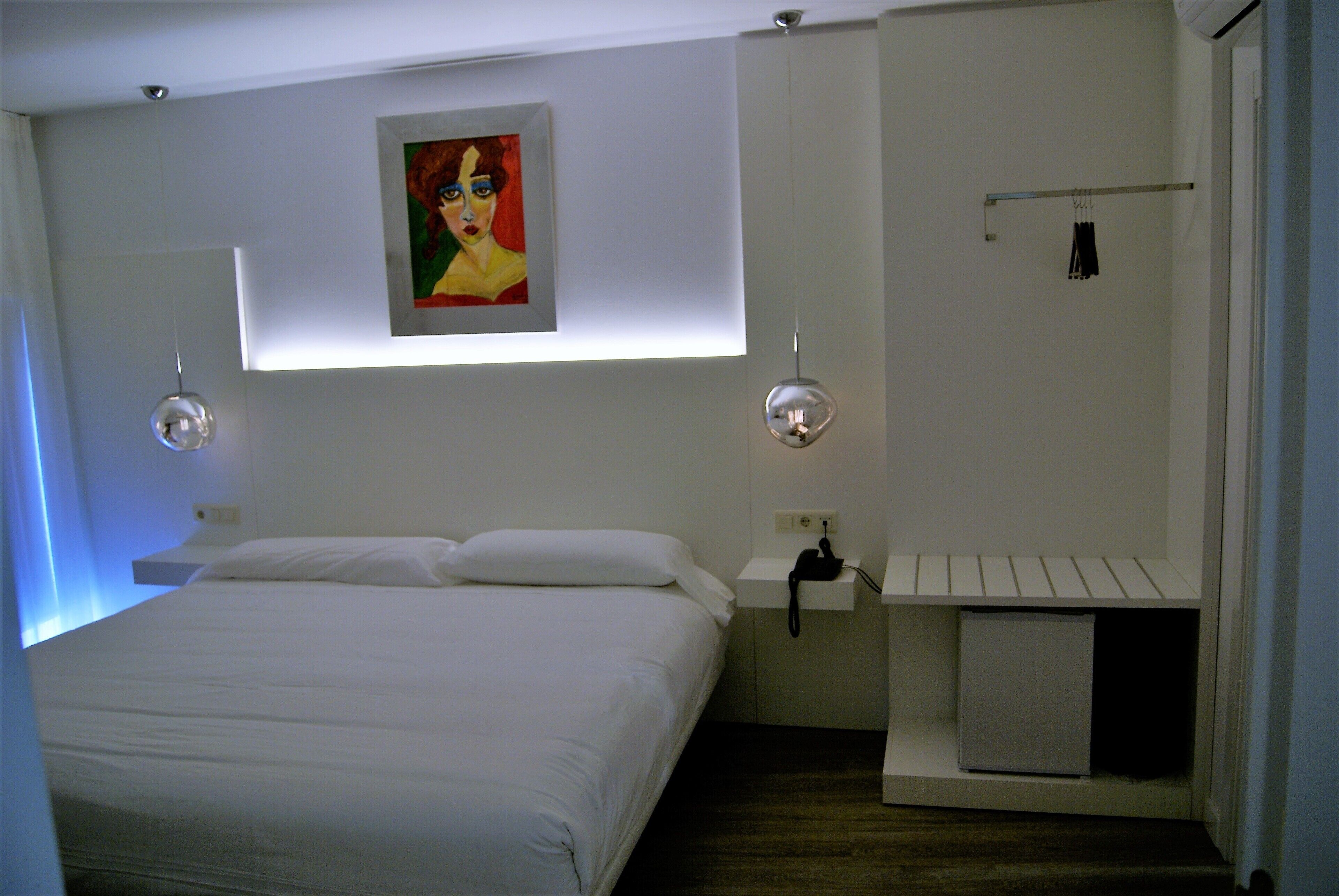 Ein Schlafzimmer mit Bett, Nachttisch und einem kleinen Schrank.