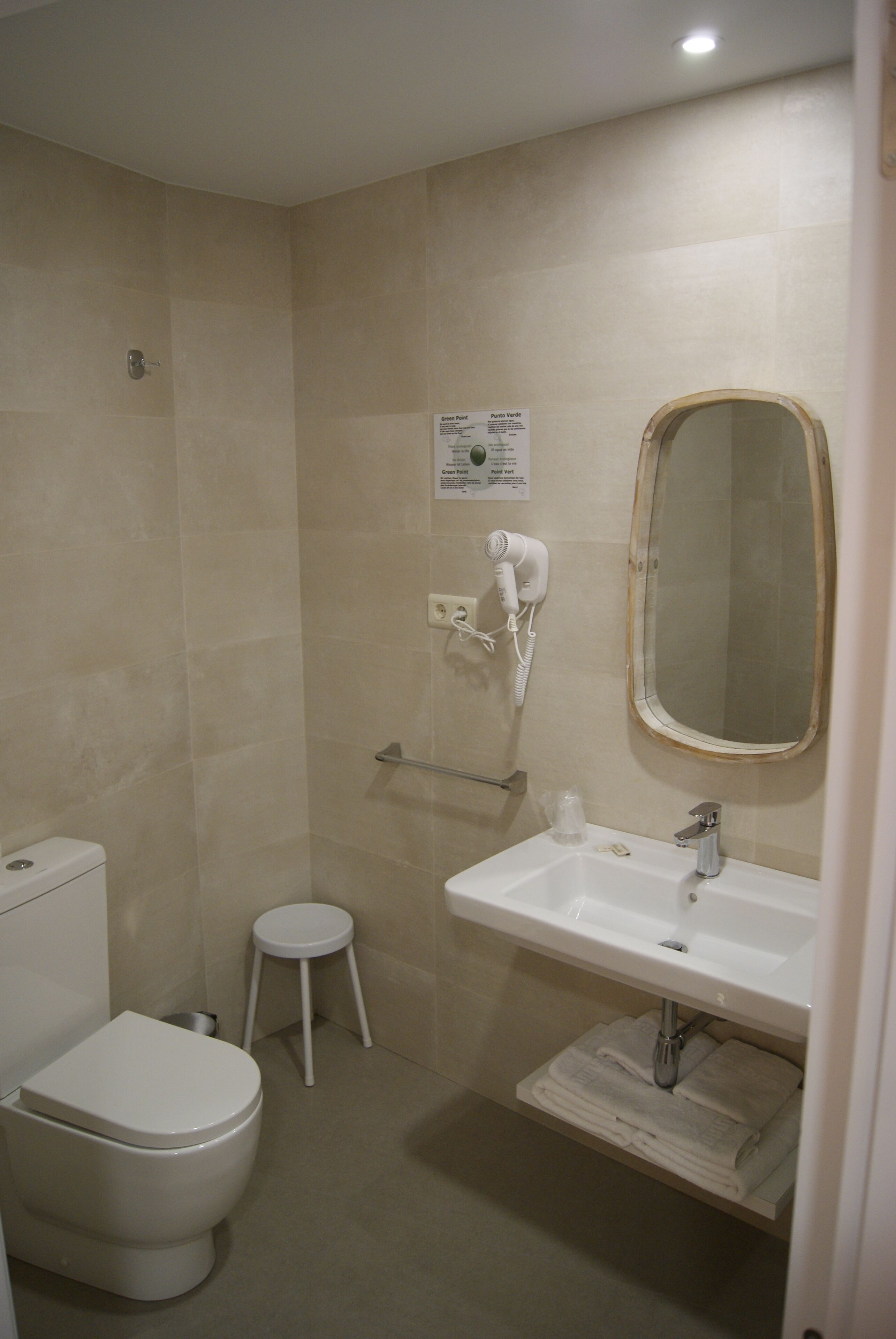Un bagno con il water, un lavandino e uno specchio.