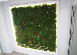 A wall with a moss-like texture and small white flowers. - Hotel La Encomienda (Moraleja)