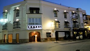 Un hotel con un llamativo letrero que dice 'HOTEL', varios balcones y una entrada bien iluminada.