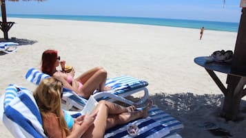 On the beach, white sand, sun loungers, beach umbrellas