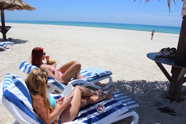 On the beach, white sand, sun loungers, beach umbrellas