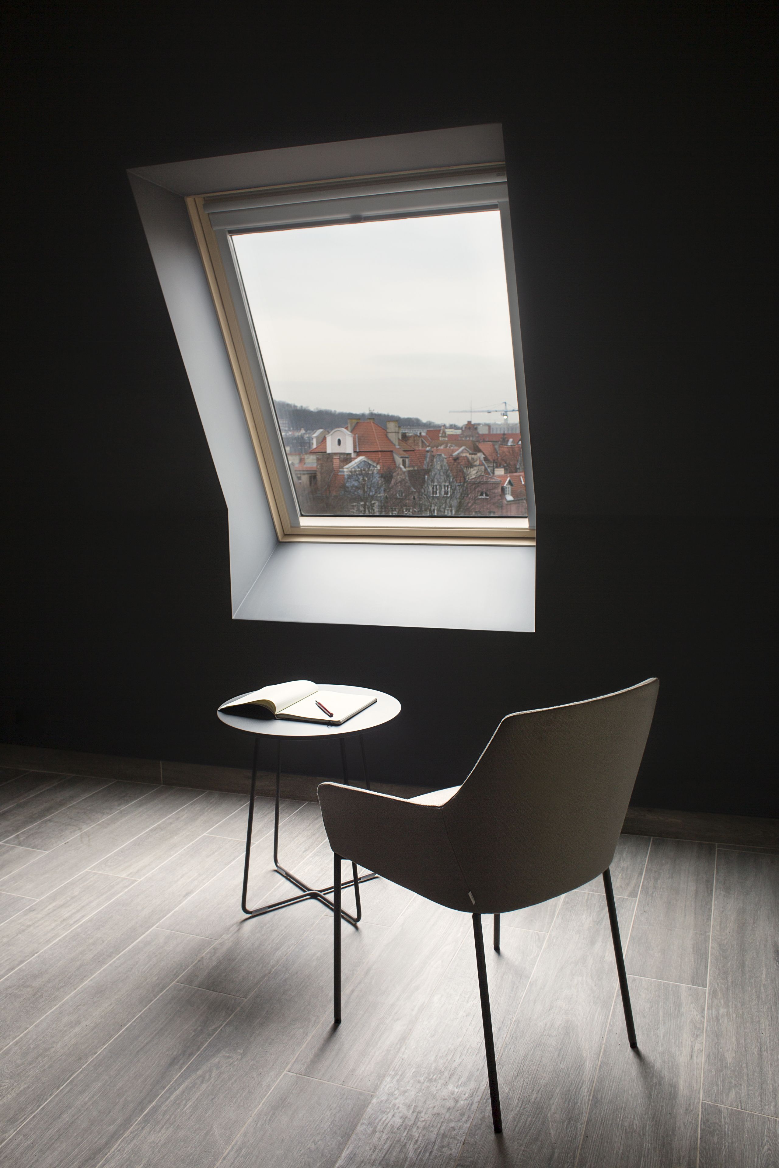 A room with a skylight, a table, and a chair.