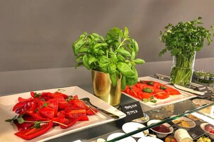 Un bufé con diversos platos, incluyendo pimientos rojos en rodajas y un letrero que indica 'Paprika Pepper'.